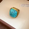 Detailed macro view of vintage square turquoise-style stone ring with gold textured band - Blue Ring