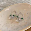 Primo piano dettagliato di orecchini a cerchio in argento con perle opache e tocchi verdi - Stile in Ferro (HE33509) / Argento-Verde-Rosa