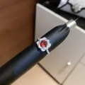 Macro detail of a sparkling red zircon flower ring on a black display mandrel - Silver-Red