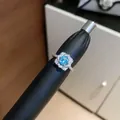 Detailed macro shot of a shiny silver-plated open ring with a light blue zircon flower - Silver-Blue