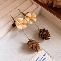 Close-up of vintage forest-style earrings with cream flowers and natural pinecone pendants. - Hazelnut Pendant Style (HE33613) / White