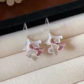 Dettaglio macro di orecchini a foglia increspata in smalto bianco e rosa. - Stile a Gancio / Rosa Argento