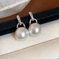 Primo piano di eleganti orecchini di perle tonde con finitura argento su velluto - Perla Tonda (HE31807) / Argento
