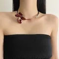 Vista dettagliata di un girocollo a fiore di iris in smalto bordeaux con piccoli strass - Girocollo Iris / Argento-Rosso