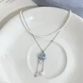 Detailed macro shot of a layered necklace featuring a blue cloud and star tassel - Double-layered Style / Silver-White