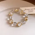 Detailed view of a crystal-clear beaded bracelet with sparkling gold diamond accents. - Bracelet / Gold