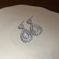 Vista dettagliata di orecchini a goccia placcati in oro 18 carati con zirconi brillanti. - Argento
