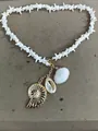 Bohemian starfish necklace with gold spiral shell and white cowrie shell pendants. - Gold-White