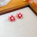 Dettaglio degli orecchini vintage a forma di fiore dipinto a olio con perla bianca - Rosa