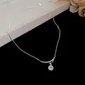 Close-up of elegant zircon flower pendant necklace on a premium black background - White