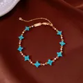 Close-up of gold bracelet with blue flower motifs and crystals on brown fabric - No 5 Four-Petal Floral Style
