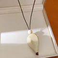 Gros plan d'un pendentif goutte ivoire élégant présenté dans son bel écrin à bijoux. - Kaki