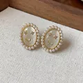 Macro detail of 14k gold plated smiley face earrings with pearls and cat eye stone. - Silver Post Smile Style / Gold