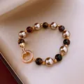 Gedetailleerd overzicht van een elegante Franse kralenarmband met parels en kristallen sluiting - Vergulde Parel Tijgeroog Stijl (3#)