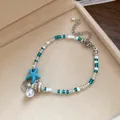 Close-up of beach style beaded bracelet with starfish, shell charms and pearl detail - Silver-Blue