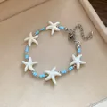 Detailed view of beach style bracelet featuring white starfish and light blue beads - Silver-White-Blue