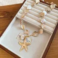 Detail view of seaside vacation necklace with irregular shells and starfish charm - Gold & Coffee
