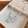 Detailed shot of a beach-style blue starfish and shell beaded necklace in a jewelry box - White Dove Blue