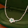 Close-up detail of a vintage style necklace with green zircon flower in a green velvet box - Necklace / Silver-Green