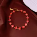Elegant gold bracelet featuring sparkling red crystal four-leaf clover charms on brown silk. - No 21 Red Clover Style