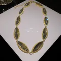 Detailed close-up of a marquise-cut grey crystal necklace with gold textured setting. - Necklace (HN12593) / Gold-White