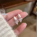 Detailed view of elegant zircon water drop tassel earrings with shimmering white pearls - Copper Material / Silver