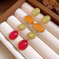 Close-up detail of vintage colorful resin oval drop earrings set in a velvet jewelry box - Silver Post Oval Pendant Style / Green Orange Pink Patchwork