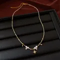 Close-up of a handmade beaded necklace featuring white pearls and a gold star charm - Gold-Green