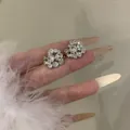 Detailed macro view of luxurious silver flower ear cuffs with micro-paved rhinestones - No Piercing Ear Clip (HE33843-1-) / Silver