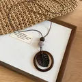 Detail view of a Bohemian monstera leaf pendant necklace on a rustic wooden display - 3# Necklace-Coffee