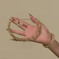 Vista macro dettagliata di collana, bracciale e orecchini scintillanti con strass - Set di Orecchini Bracciale e Collana / Set da 3 pezzi / Oro