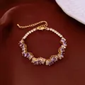 Elegant gold-toned bracelet featuring purple and clear crystals on a dark background. - No 47 Purple Waterdrop Splicing Style