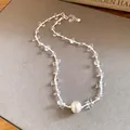 Close-up view of an elegant clear beaded necklace featuring a frosted silver ball pendant - Necklace / Silver & White