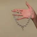 Dettaglio di un set di gioielli con motivo a fiori e pietre di zirconio scintillanti - Set di Orecchini e Collana / Set da 2 pezzi / Argento