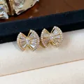 Macro view of geometric 18k gold plated stud earrings featuring intricate zircon settings. - Geometric Bowknot Style (HE31353) / Gold
