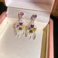 Close-up of vintage flower tassel earrings with colorful heart-shaped zircons - Colorful