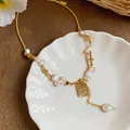 Elegant gold pearl necklace featuring irregular pearls and 'good luck' engraved charm detail - Necklace - Gold - White