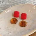 Close-up of geometric red and amber resin drop earrings in a stylish Korean design - Square and Round Patchwork Style / Red And Amber