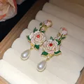 Gros plan sur des boucles d'oreilles rose en émail vintage avec perles élégantes - Fleur Perle Vintage (HE32805) / Or-Rose