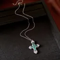 Exquisite detail of a silver cross pendant necklace with green and white zircon stones. - Necklace / Silver-Green