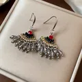 Gros plan sur des boucles d'oreilles vintage en forme d'éventail avec strass - Style Crochet / Argent-Gris