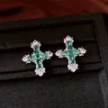 Close-up of vintage cross stud earrings featuring brilliant green and clear zirconia stones - Stud Earrings / Silver-Green
