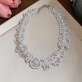 Gros plan d'un collier de perles vintage français avec détails en dentelle de cristal - Collier-Grand / Blanc