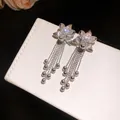 Detailed view of silver flower earrings with zircon center and dangling bead tassels - 18K Gold Plated (Silver Needle) / Silver