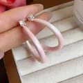 Primer plano de elegantes pendientes de esmalte rosa en forma de C con circonitas. - Estilo en Forma de C / Grande / Rosa