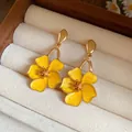 Detailed view of vintage gold-tone flower drop earrings featuring yellow enamel petals - Yellow