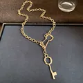 Vintage gold chain necklace featuring a unique key pendant on a minimalist display tray - Key Style / Gold