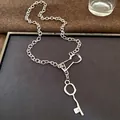 High-quality detail shot of a retro silver metal chain necklace featuring a unique key pendant - Key Style / Silver