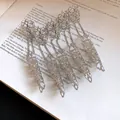 Macro detail of silver Gothic filigree finger armor rings laid on vintage book pages - Finger Armor Ring (HR3460) / Silver