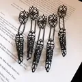 Gothic style black filigree hollow finger armor rings with chain detail on a book page - Finger Armor Ring (HR3460) / Black
